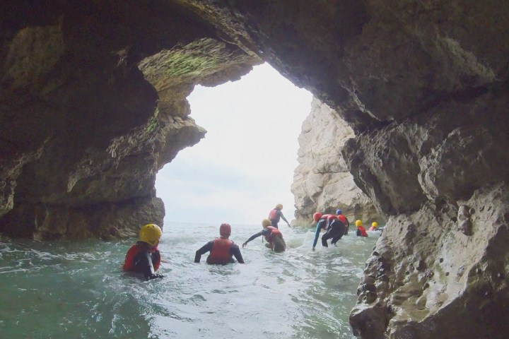 a group of people on a rock next to water